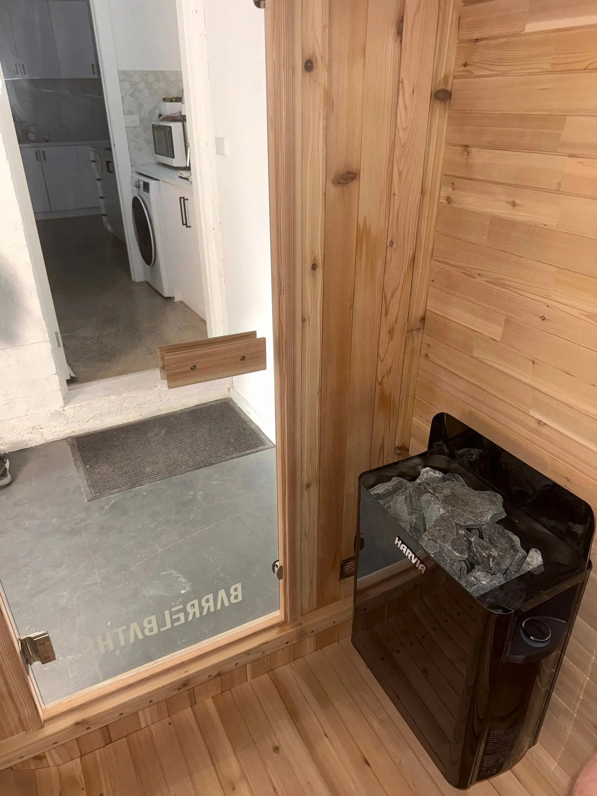 cube sauna inside, harvia heater installed on the wall